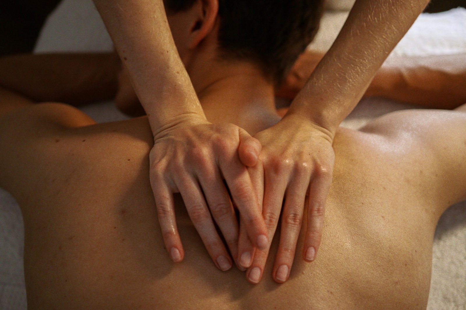 Top view of a relaxing massage session focused on the back with a bokeh effect.